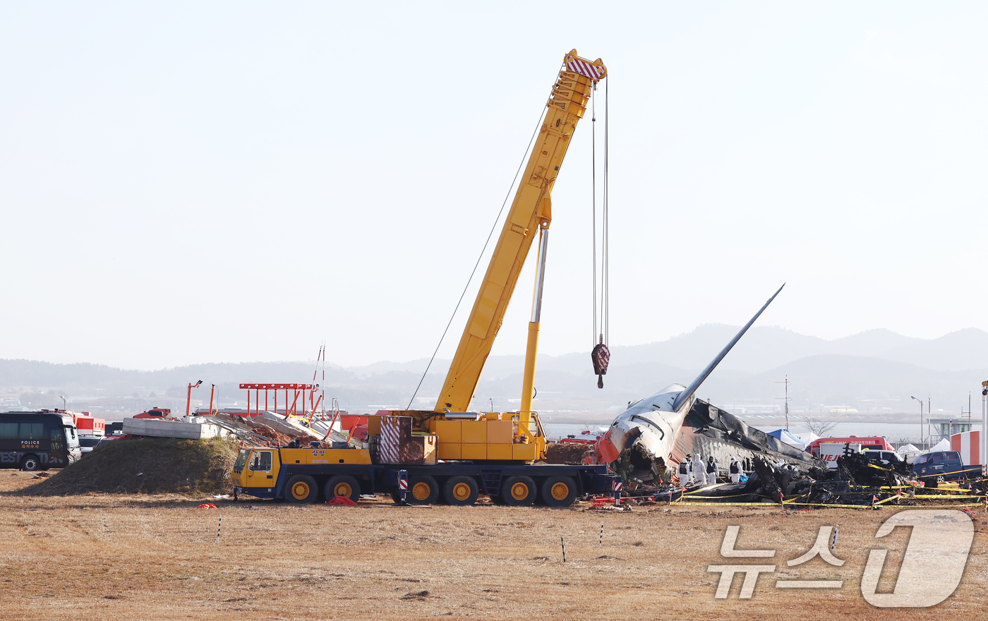 (무안=뉴스1) 김민지 기자 = 31일 오전 전남 무안국제공항 제주항공 여객기 참사 현장에 사고 여객기와 충돌로 부서진 방위각 시설(로컬라이저), 대형크레인 등이 보이고 있다. 2 …