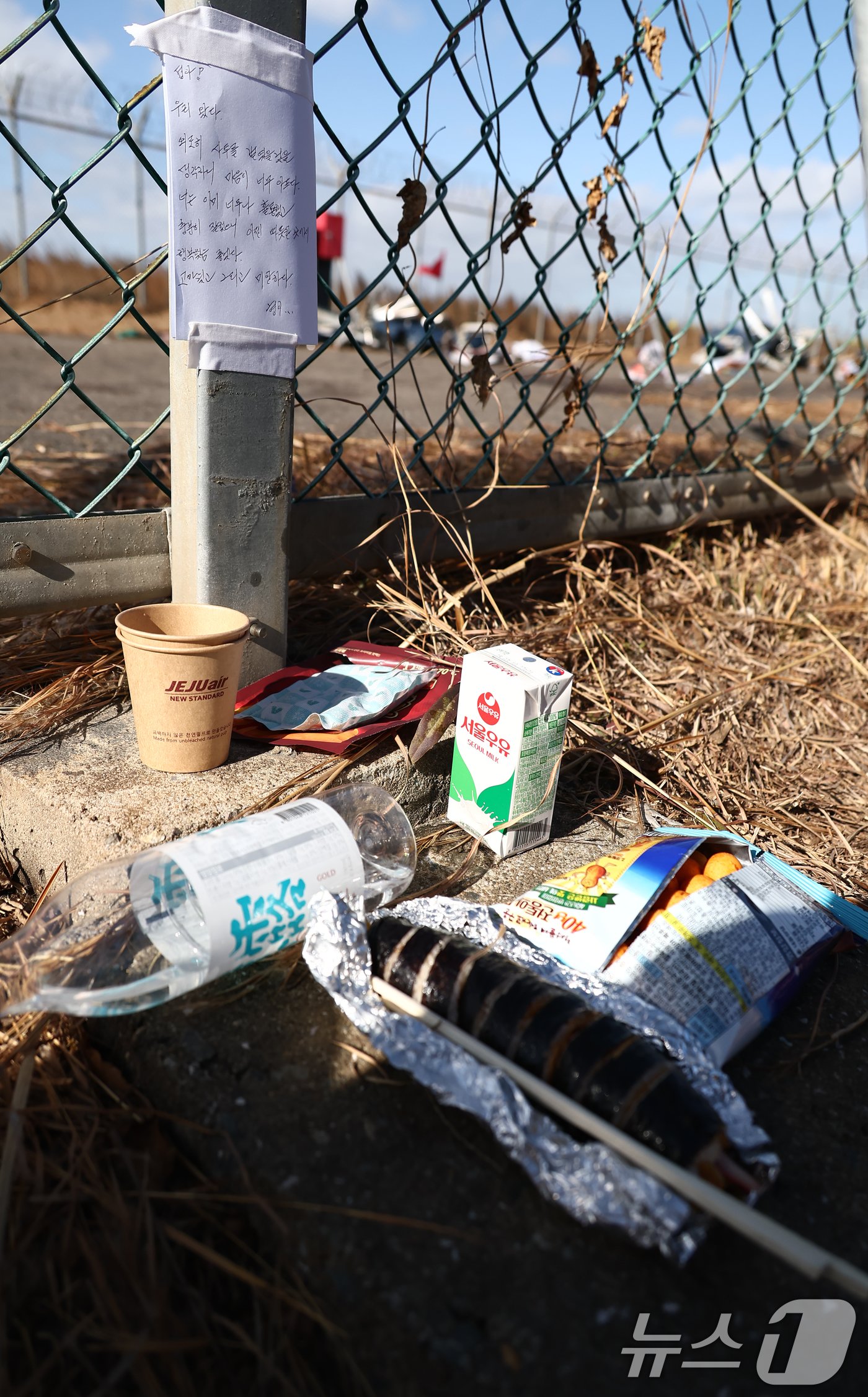 본문 이미지 - 31일 전남 무안국제공항 제주항공 여객기 참사 현장에 유가족이 쓴 편지와 술 등이 놓여 있다. 2024.12.31/뉴스1 ⓒ News1 김민지 기자