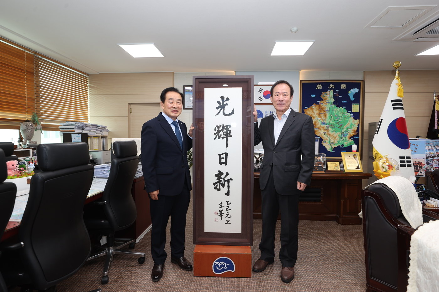 본문 이미지 - 한학자 지봉 정우식 선생&#40;오른쪽&#41;이  송기섭 진천군수에게 2025년 사자휘호 서예작품을 기증하고 있다. 