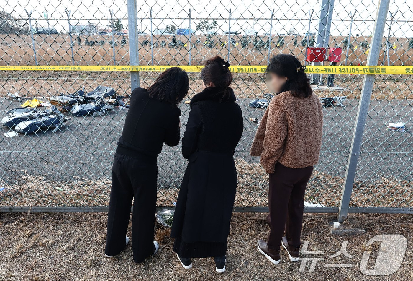 31일 전남 무안국제공항 제주항공 여객기 참사 현장에서 추모객들이 희생자들을 기리는 편지를 붙이고 있다. 2024.12.31/뉴스1 ⓒ News1 김민지 기자