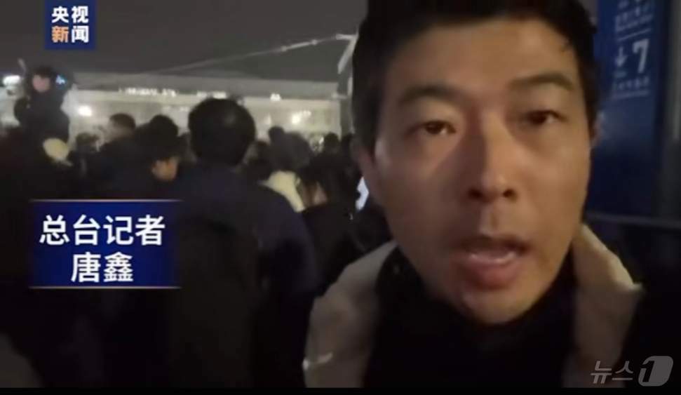 본문 이미지 - CCTV 한국 주재 기자가 3일 밤 국회 앞 대치 상황을 보도하고 있다.