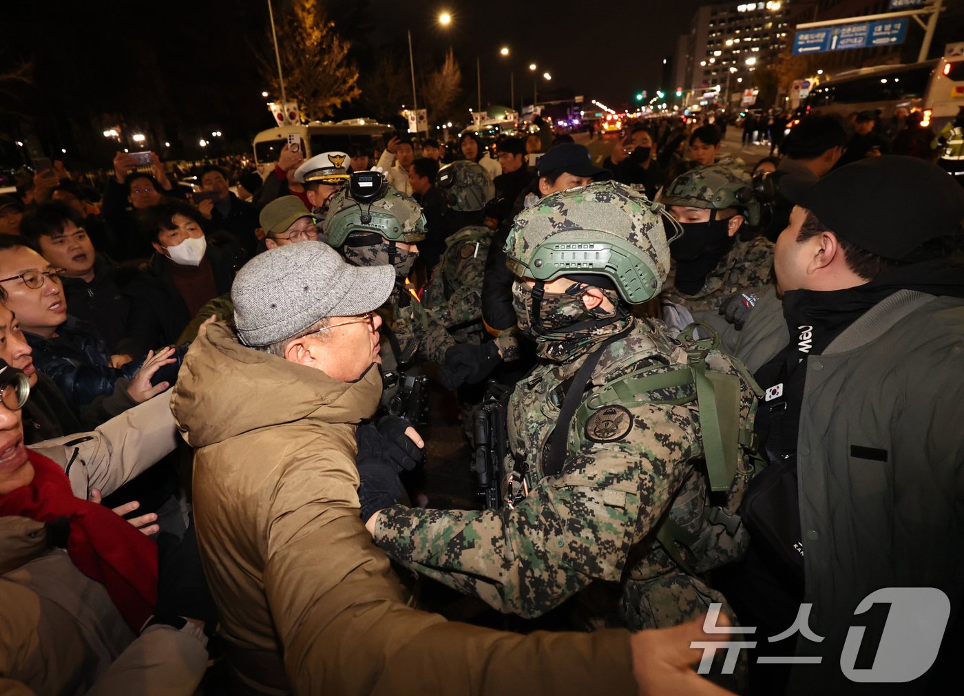 본문 이미지 - 윤석열 대통령이 비상계엄령을 선포한 가운데 4일 새벽 서울 여의도 국회 앞에 모인 시민들이 계엄군 진입을 막아서고 있다. 2024.12.4/뉴스1 ⓒ News1 구윤성 기자