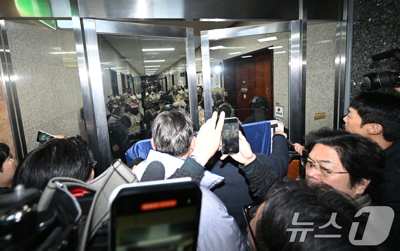 본문 이미지 - 윤석열 대통령이 전격적으로 비상계엄령을 선포한 4일 새벽 계엄군들이 국회 본청 진입을 시도하자 국회 보좌진 등 직원들이 대치하고 있다. 2024.12.4/뉴스1 ⓒ News1 김민지 기자
