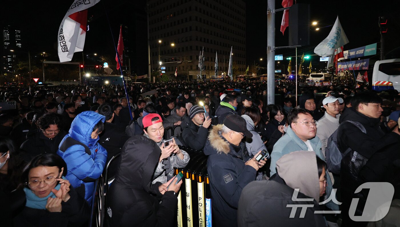 본문 이미지 - 윤석열 대통령의 비상계엄 해제 요구 결의안이 국회 본회의에서 통과된 4일 새벽 서울 여의도 국회 정문 앞에 모인 시민들이 윤 대통령을 규탄하고 있다. 2024.12.4/뉴스1 ⓒ News1 장수영 기자