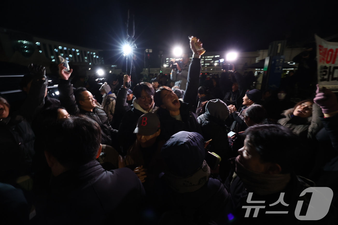 (서울=뉴스1) 이재명 기자 = 비상계엄 해제 요구 결의안이 국회 본회의에서 통과된 4일 새벽 서울 여의도 국회 인근에서 시민들이 윤석열 대통령의 비상계엄 해제 관련 담화를 지켜보 …