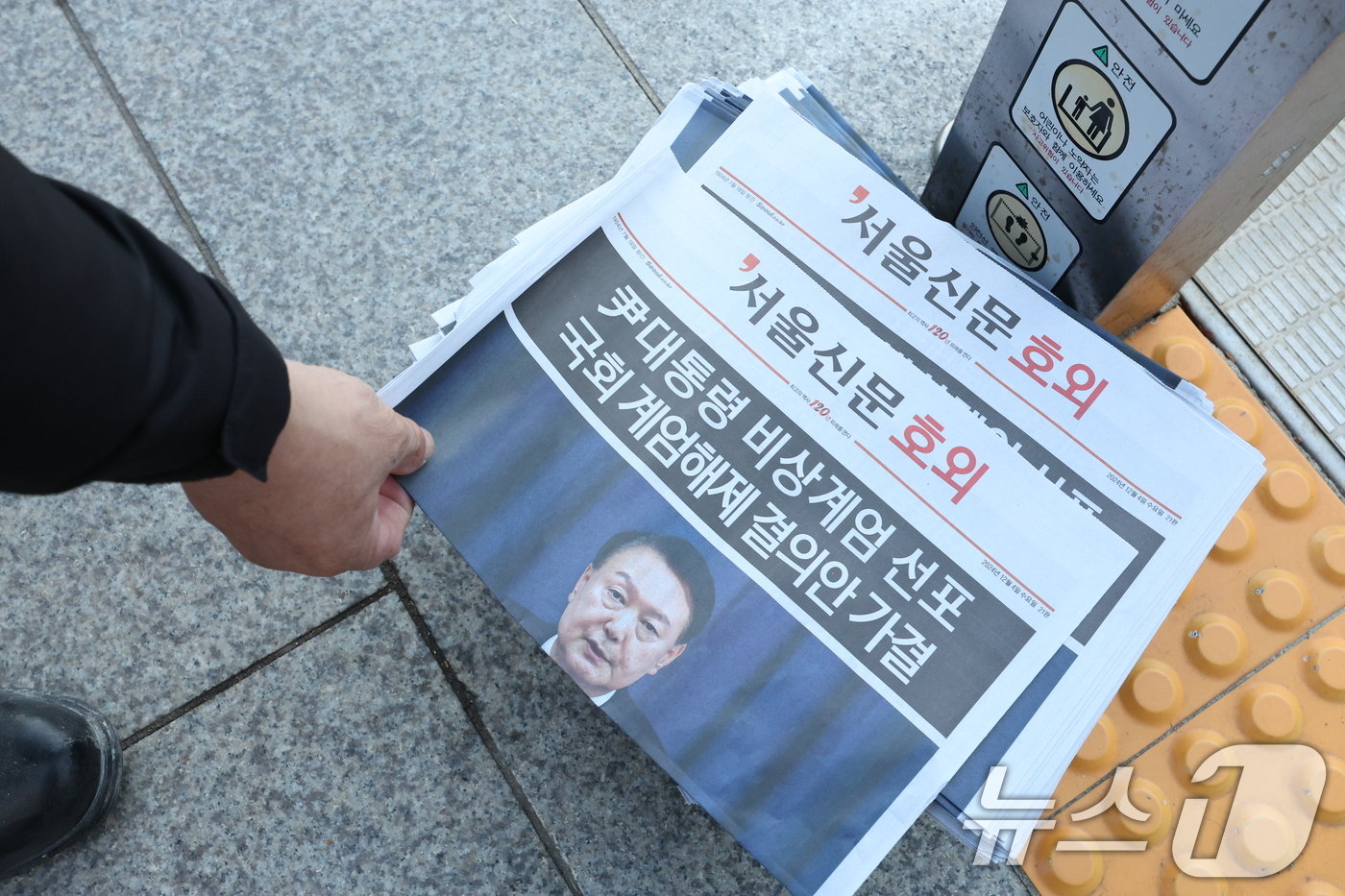 본문 이미지 - 윤석열 대통령이 비상계엄을 선포한 지 6시간여만에 국무회의에서 계엄 해제안이 의결된 가운데 4일 오전 서울 종로구 광화문역 인근에서 출근길 시민들이 호외를 가져가고 있다. 2024.12.4/뉴스1 ⓒ News1 신웅수 기자