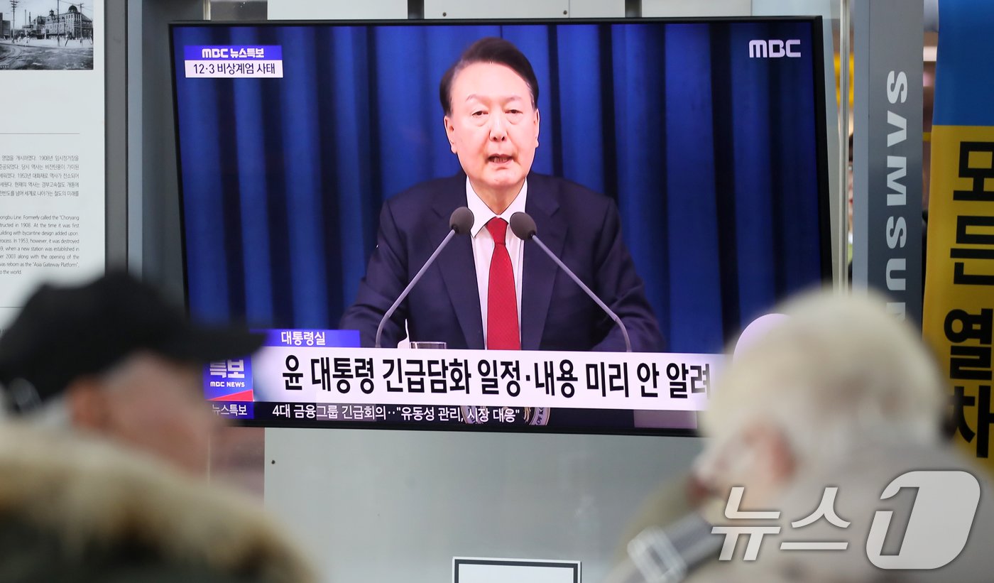 본문 이미지 - 비상 계엄이 해제된 4일 부산 동구 부산역 대합실에서 외국인들이 윤석열 대통령의 비상 계엄 선포와 관련한 뉴스를 보고 있다. 2024.12.4/뉴스1 ⓒ News1 윤일지 기자