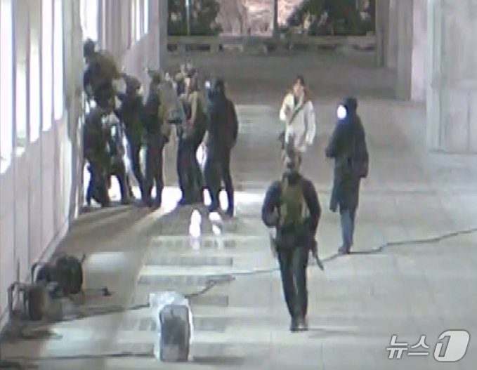 본문 이미지 - 국회사무처가 계엄군의 국회 본관 진입 과정이 담긴 CCTV를 4일 공개했다. 김민기 국회사무총장은 국방부가 헬기로 24차례에 걸쳐 무장한 계엄군 230여 명을 국회 경내로 진입시켰다며 0시 40분에는 계엄군 50여 명을 추가로 국회 외곽 담장을 넘어 진입시켰다고 전했다. 사진은 창문을 깨고 국회 진입하는 계엄군 모습. &#40;국회사무처 제공&#41; 2024.12.4/뉴스1