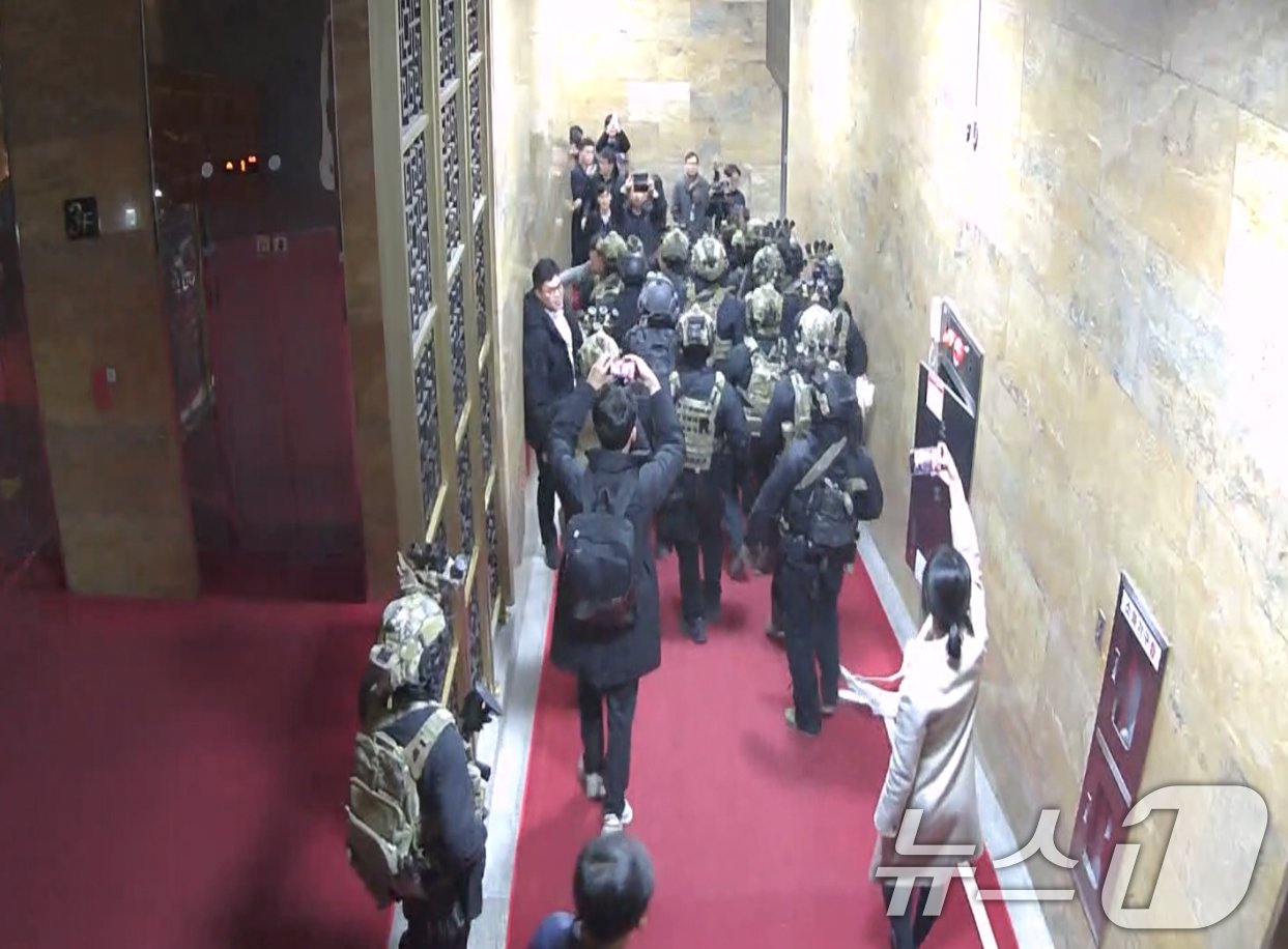 본문 이미지 - 국회사무처가 계엄군의 국회 본관 진입 과정이 담긴 CCTV를 4일 공개했다. 김민기 국회사무총장은 국방부가 헬기로 24차례에 걸쳐 무장한 계엄군 230여 명을 국회 경내로 진입시켰다며 0시 40분에는 계엄군 50여 명을 추가로 국회 외곽 담장을 넘어 진입시켰다고 전했다. 사진은 창문을 깨고 국회에 진입한 계엄군 모습. &#40;국회사무처 제공&#41; 2024.12.4/뉴스1