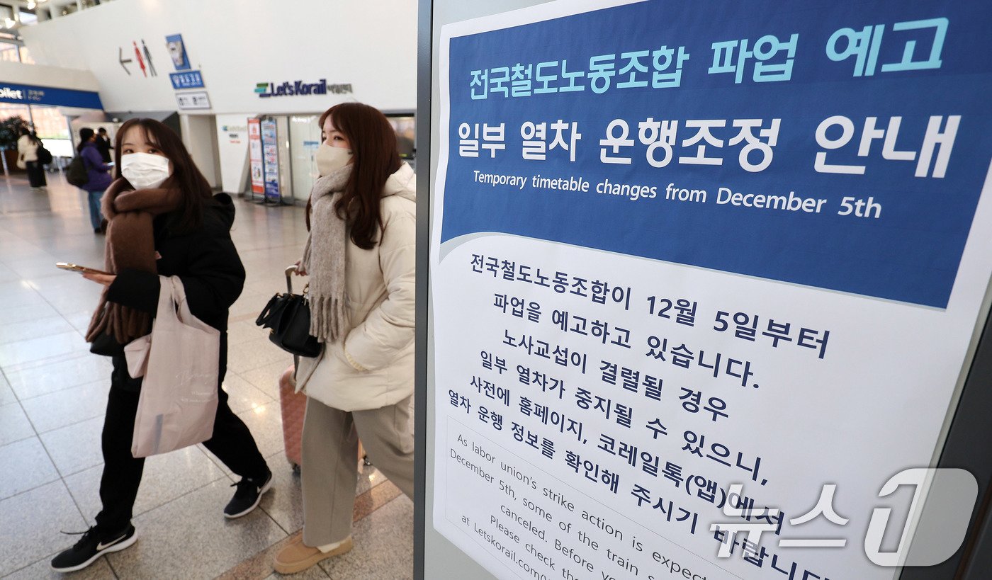 본문 이미지 - 전국철도노동조합 총파업을 하루 앞둔 4일 서울역에 게시된 파업 예고 관련 열차 운행조정 안내문 앞으로 외국인 관광객이 지나가고 있다. 철도노조는 이날 진행되는 사측과의 막판 교섭에서까지 타결이 안되면 파업에 돌입한다는 입장이다. 2024.12.4/뉴스1 ⓒ News1 박지혜 기자