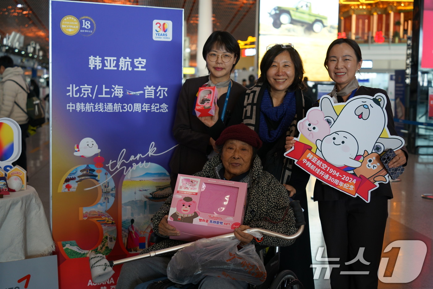 (서울=뉴스1) = 4일 중국 베이징 서우두 공항에서 열린 아시아나항공 중국 취항 30주년 기념 행사에서 탑승객과 직원들이 기념촬영을 하고 있다. (아시아나항공 제공) 2024.1 …