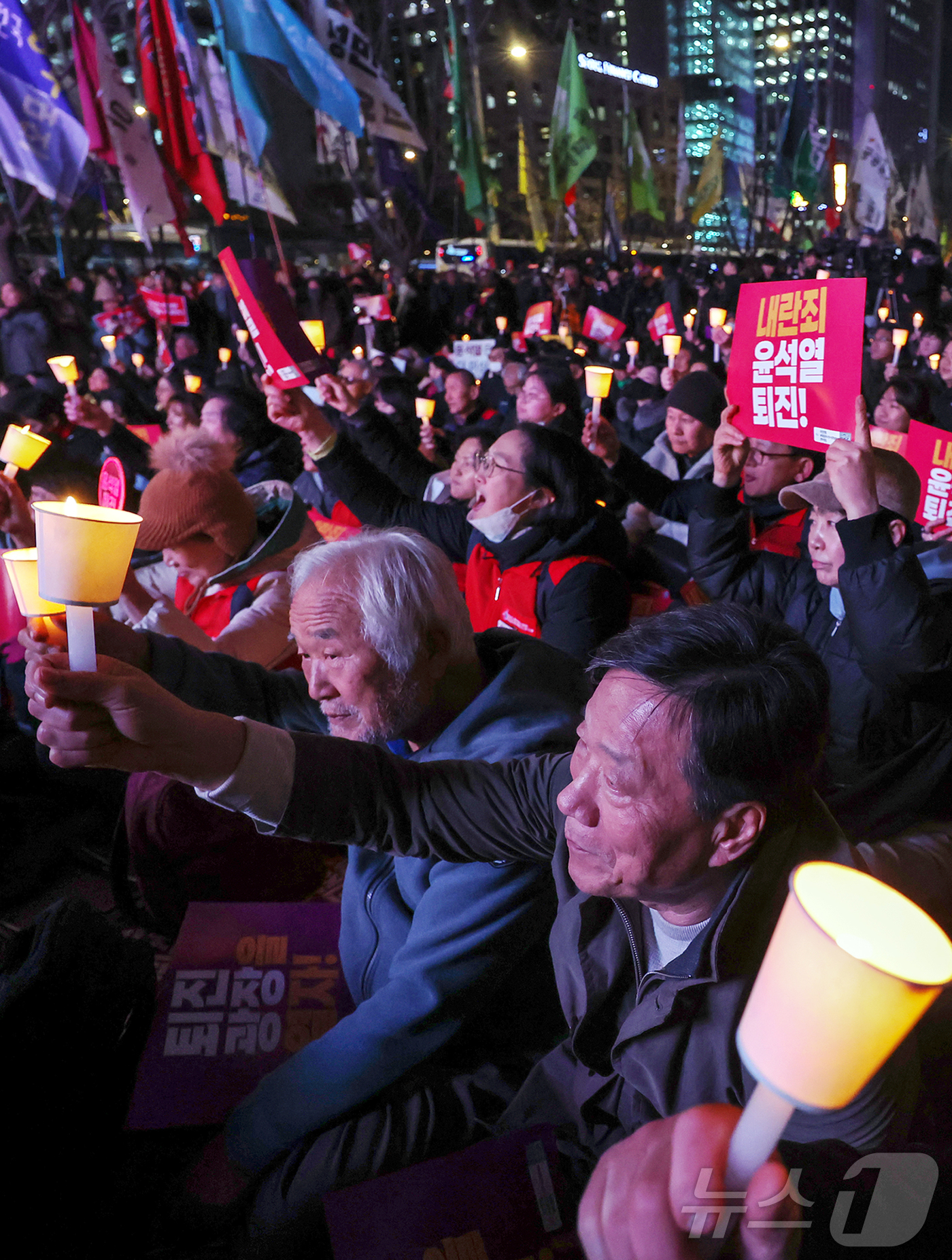 (서울=뉴스1) 민경석 기자 = 시민사회단체 관계자들이 4일 오후 서울 종로구 동화면세점 앞에서 윤석열 대통령의 퇴진을 촉구하는 촛불집회를 하고 있다. 2024.12.4/뉴스1