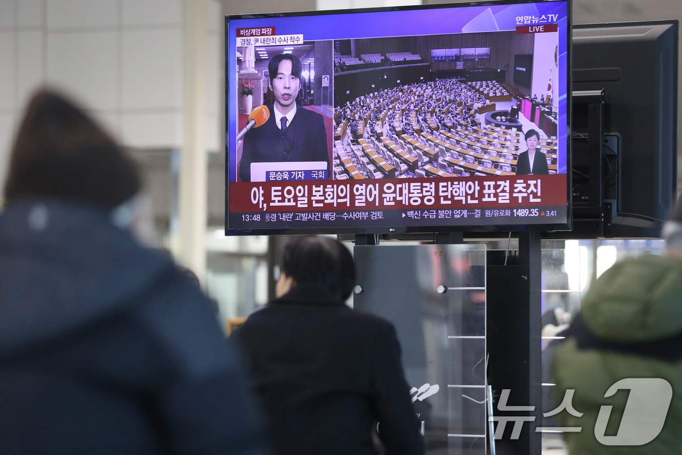 (오산=뉴스1) 김영운 기자 = 5일 경기 오산시 오산역 환승센터 대합실에서 시민들이 윤석열 대통령의 탄핵 관련 뉴스를 시청하고 있다. 2024.12.5/뉴스1