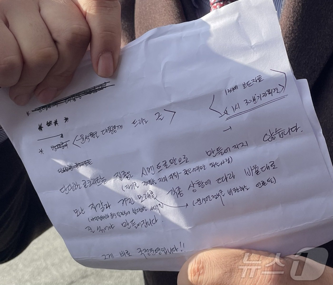 본문 이미지 - 공천 거래 혐의로 구속기소된 명태균 씨 측 변호인이 5일 경남 창원시 창원지방검찰청 앞에서 기자회견을 열고 명 씨가 윤 대통령에게 전달한 메시지를 대독했다. 사진은 변호인이 명 씨가 불러준 메시지 내용을 적은 종이를 들고 있는 모습.2024.12.5/뉴스1 ⓒ News1 강정태 기자