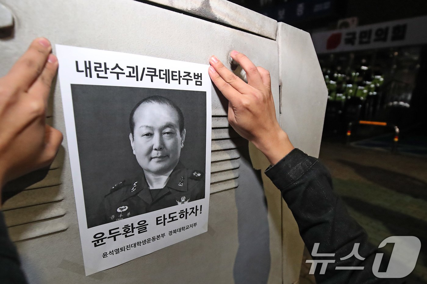 본문 이미지 - 5일 오후 대구 중구 동성로에서 열린 대구시민시국대회 참가자들이 수성구 범어동 국민의힘 대구경북 당사까지 행진한 뒤 한 참가자가 윤석열 대통령과 내란죄로 처벌받은 전두환 전 대통령을 합성한 포스터를 붙이고 있다. 2024.12.5/뉴스1 ⓒ News1 공정식 기자