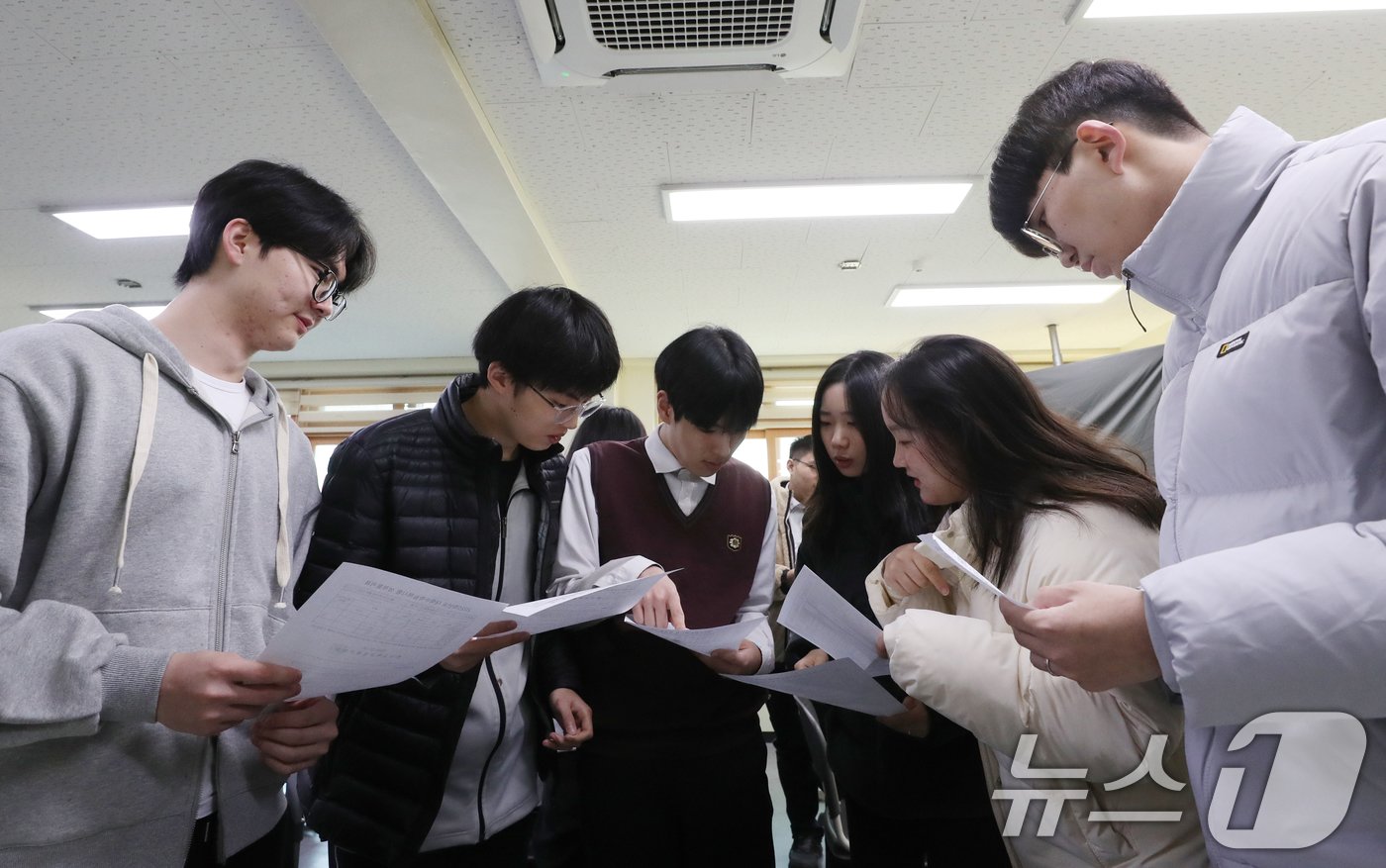 본문 이미지 - 2025학년도 대학수학능력시험&#40;수능&#41; 성적표가 배부된 6일 오전 경기 수원시 영통구 효원고등학교에서 성적표를 받은 학생들이 수능 성적을 확인하고 있다. 2024.12.6/뉴스1 ⓒ News1 김영운 기자