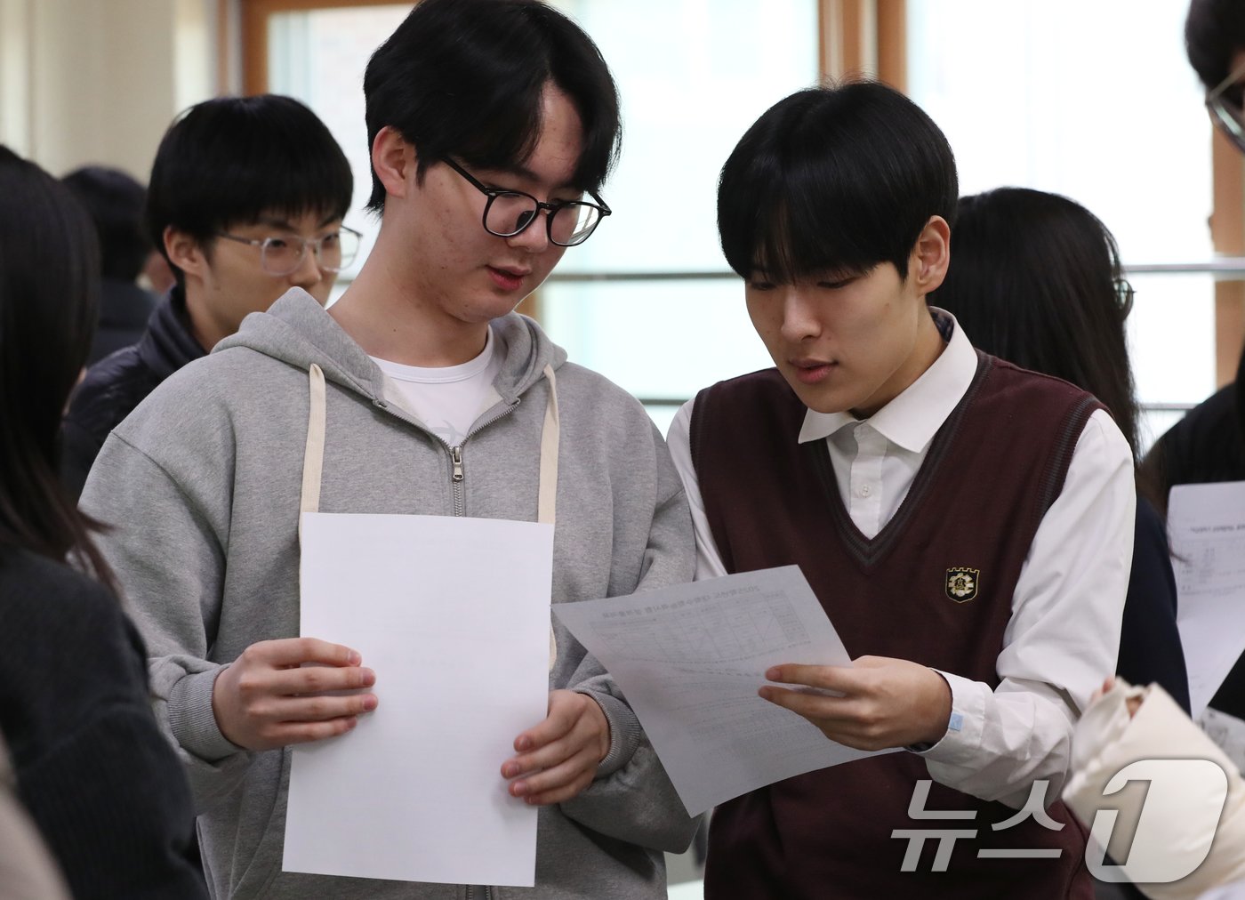 본문 이미지 - 2025학년도 대학수학능력시험&#40;수능&#41; 성적표가 배부된 6일 오전 경기 수원시 영통구 효원고등학교에서 성적표를 받은 학생들이 수능 성적을 확인하고 있다. 2024.12.6/뉴스1 ⓒ News1 김영운 기자