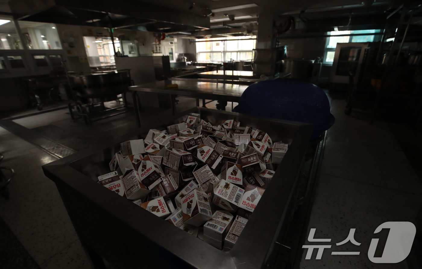 본문 이미지 - 학교 급식·돌봄 업무에 종사하는 비정규직 노동자들이 총파업에 돌입한 6일 부산 시내 한 초등학교 급식실에 불이 꺼져 있는 가운데 대체급식으로 준비된 우유, 바나나 등이 놓여 있다. 2024.12.6/뉴스1 ⓒ News1 윤일지 기자