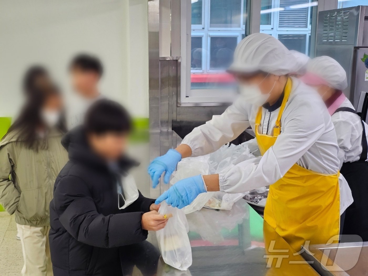 본문 이미지 - 학교 조리실무사 등 교육공무직이 총파업에 돌입한 6일 낮 창원남산초등학교에서 학교 관계자들이 학생들에게 대체급식으로 준비한 빵과 주스를 나눠주고 있다. 2024.12.6 ⓒ 뉴스1 박민석 기자