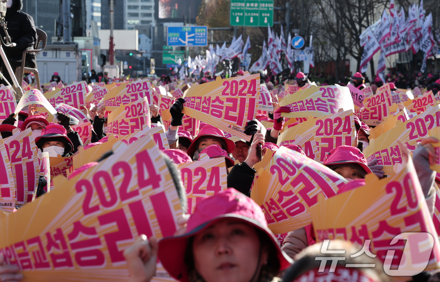 (서울=뉴스1) 김성진 기자 = 학교 급식·돌봄 업무에 종사하는 학교 비정규직 노동자들이 6일 서울 종로구 동화면세점 앞에서 총파업 결의대회를 열고 구호를 외치고 있다.전국학교비정 …