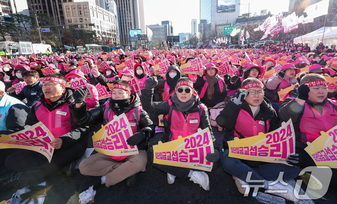 (서울=뉴스1) 김성진 기자 = 학교 급식·돌봄 업무에 종사하는 학교 비정규직 노동자들이 6일 서울 종로구 동화면세점 앞에서 총파업 결의대회를 열고 구호를 외치고 있다.전국학교비정 …