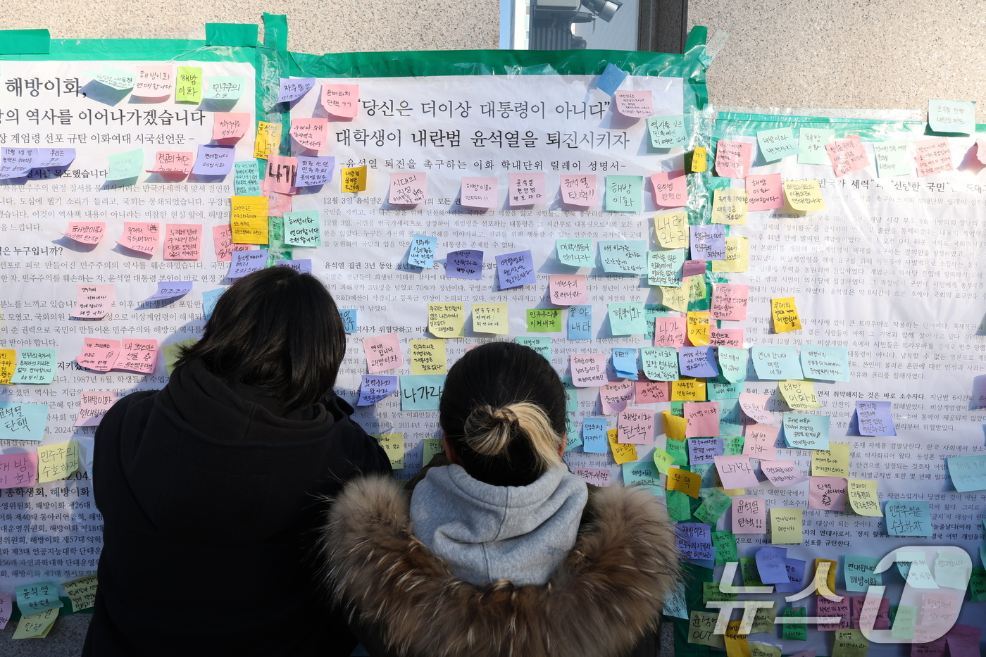 (서울=뉴스1) 신웅수 기자 = 이화여대 재학생들이 6일 오후 서울 서대문구 이화여대 앞에서 윤석열 대통령의 퇴진을 촉구하는 시국 선언을 한 후 대자보에 메시지를 붙이고 있다. 2 …