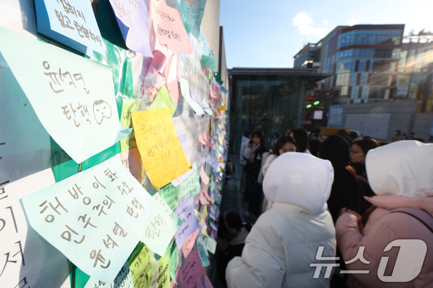 (서울=뉴스1) 신웅수 기자 = 이화여대 재학생들이 6일 오후 서울 서대문구 이화여대 앞에서 윤석열 대통령의 퇴진을 촉구하는 시국 선언을 한 후 대자보에 메시지를 붙이고 있다. 2 …