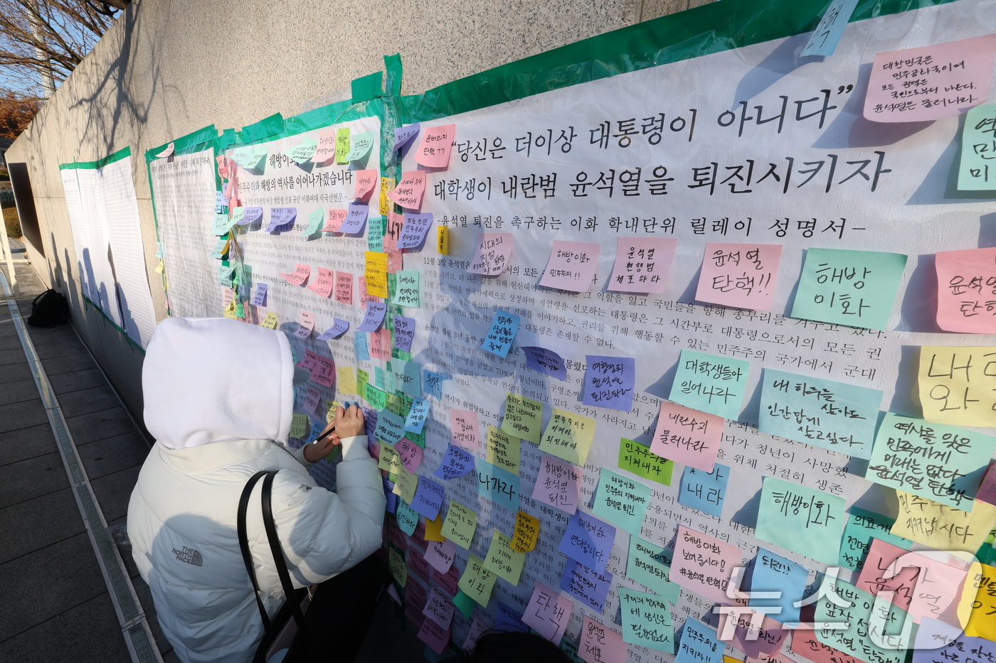 (서울=뉴스1) 신웅수 기자 = 이화여대 재학생들이 6일 오후 서울 서대문구 이화여대 앞에서 윤석열 대통령의 퇴진을 촉구하는 시국 선언을 한 후 대자보에 메시지를 붙이고 있다. 2 …