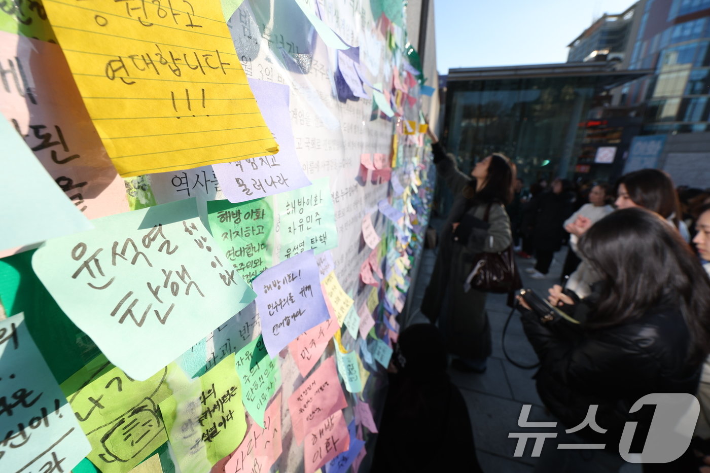 이화여대 재학생들이 6일 오후 서울 서대문구 이화여대 앞에서 윤석열 대통령의 퇴진을 촉구하는 시국 선언을 한 후 대자보에 메시지를 붙이고 있다. 2024.12.6/뉴스1 ⓒ News1 신웅수 기자