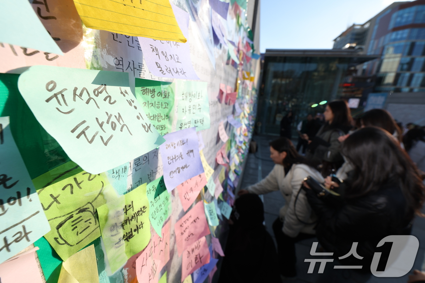 (서울=뉴스1) 신웅수 기자 = 이화여대 재학생들이 6일 오후 서울 서대문구 이화여대 앞에서 윤석열 대통령의 퇴진을 촉구하는 시국 선언을 한 후 대자보에 메시지를 붙이고 있다. 2 …