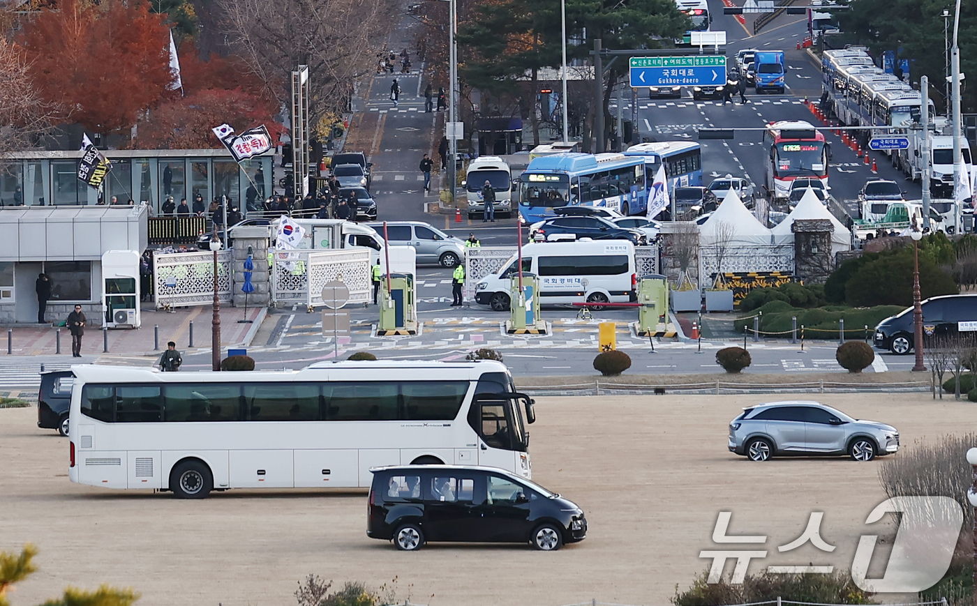 (서울=뉴스1) 김민지 기자 = 6일 오후 서울 여의도 국회 정문과 잔디광장에 헬기 착륙 방지를 위해 대형 버스 등 차량들이 배치되고 있다.이는 혹시 모를 2차 비상계엄 발생시 군 …