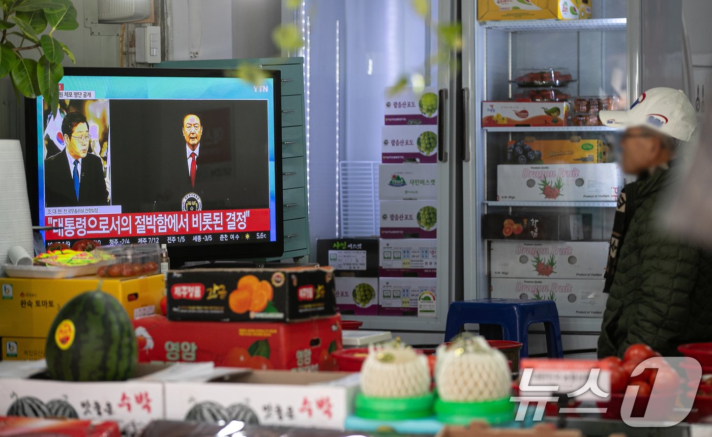 본문 이미지 - 윤석열 대통령에 대한 국회 탄핵안 표결일인 7일 오전 서울 강서구의 한 시장에서 시민들이 윤 대통령의 대국민 비상계엄 관련 담화를 시청하고 있다. 2024.12.7/뉴스1 ⓒ News1 이승배 기자