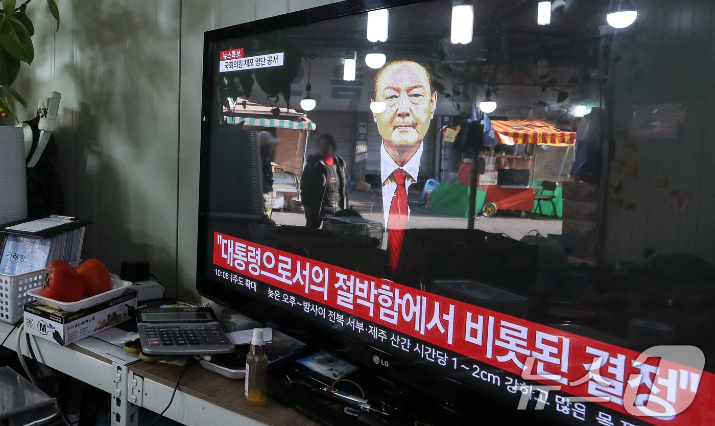 윤석열 대통령에 대한 국회 탄핵안 표결일인 7일 오전 서울 강서구의 한 시장에서 시민들이 윤 대통령의 대국민 비상계엄 관련 담화를 시청하고 있다. 2024.12.7/뉴스1 ⓒ News1 이승배 기자