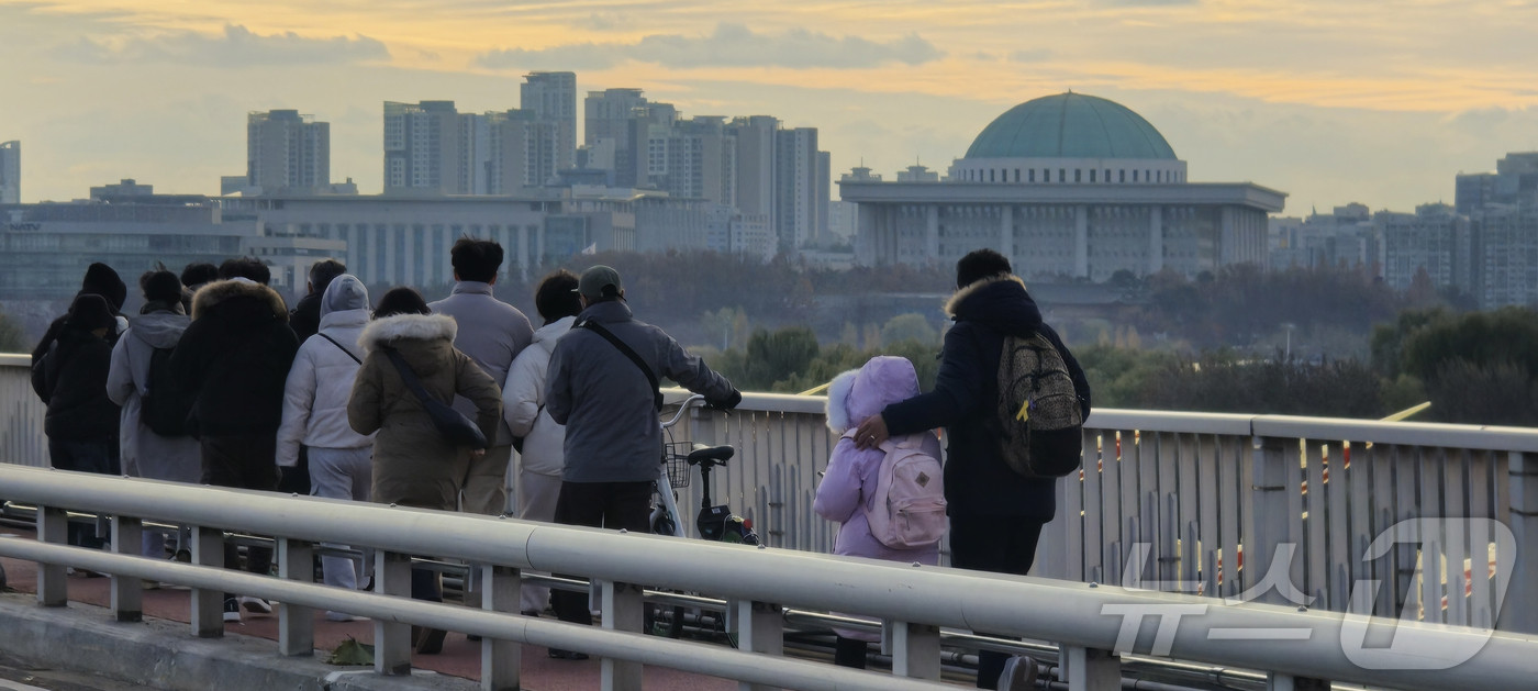 (서울=뉴스1) 김승준 기자 = 국회 탄핵소추안 표결을 앞둔 7일 오후 시민들이 서강대교를 걸으며 여의도 국회를 바라보고 있다. 2024.12.7 /뉴스1
