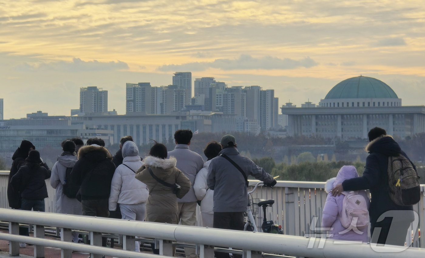 (서울=뉴스1) 김승준 기자 = 국회 탄핵소추안 표결을 앞둔 7일 오후 시민들이 서강대교를 걸으며 여의도 국회를 바라보고 있다. 2024.12.7 /뉴스1
