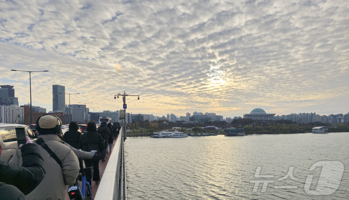 (서울=뉴스1) 김승준 기자 = 국회 탄핵소추안 표결을 앞둔 7일 오후 시민들이 서강대교를 걸으며 여의도 국회를 바라보고 있다. 2024.12.7 /뉴스1