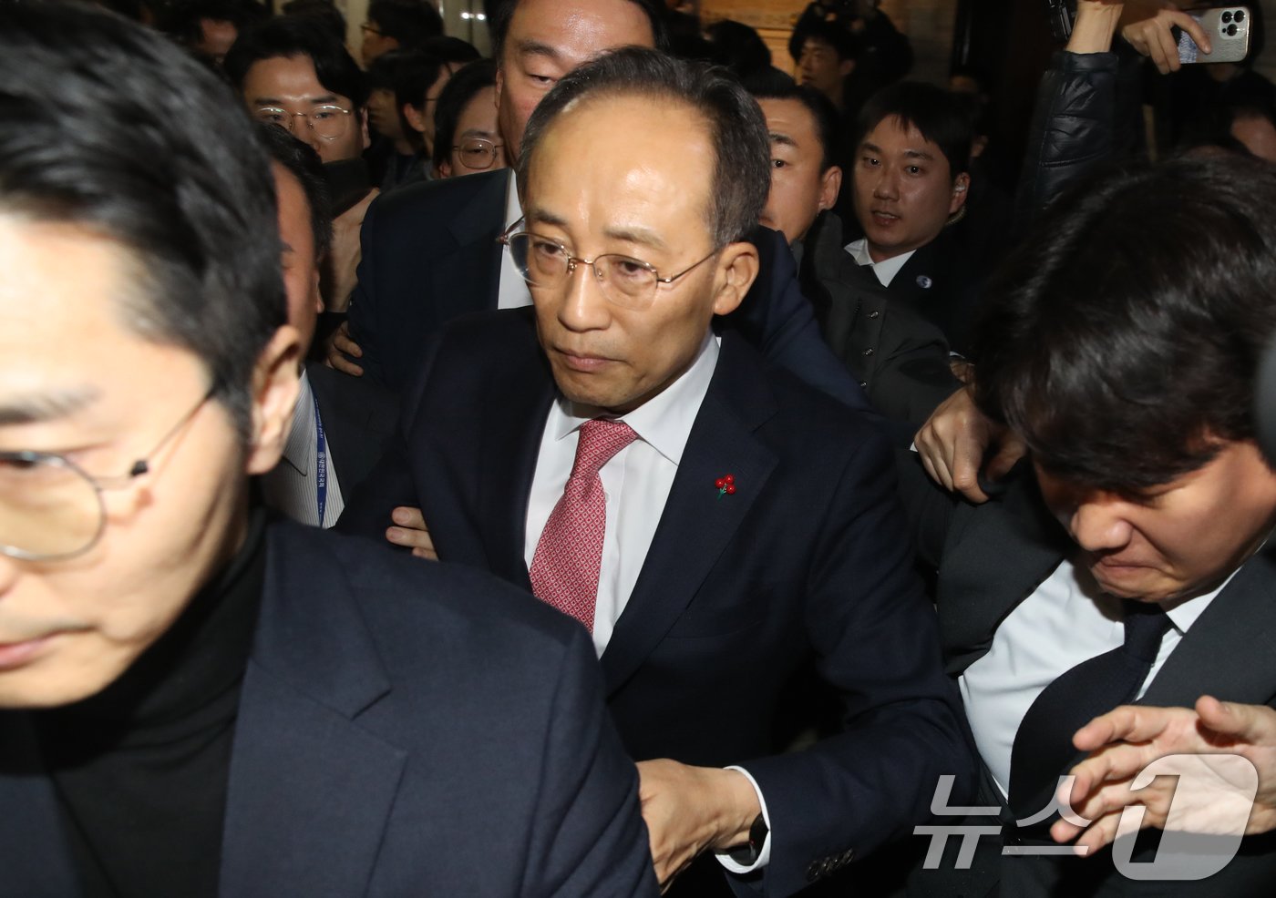 본문 이미지 - 추경호 국민의힘 원내대표가 7일 오후 서울 여의도 국회에서 의원총회를 마친뒤 항의하는 민주당 관계자들을 뒤로 하고 국회 본청을 나서고 있다. 이날 국민의힘 의원들은 김건희 특검법 투표 후 본회의장을 나가 윤석열 대통령 탄핵소추안 투표에는 참여하지 않고 의총을 계속이어가다 본회의 산회후 국회를 떠났다. 2024.12.7/뉴스1 ⓒ News1 이광호 기자