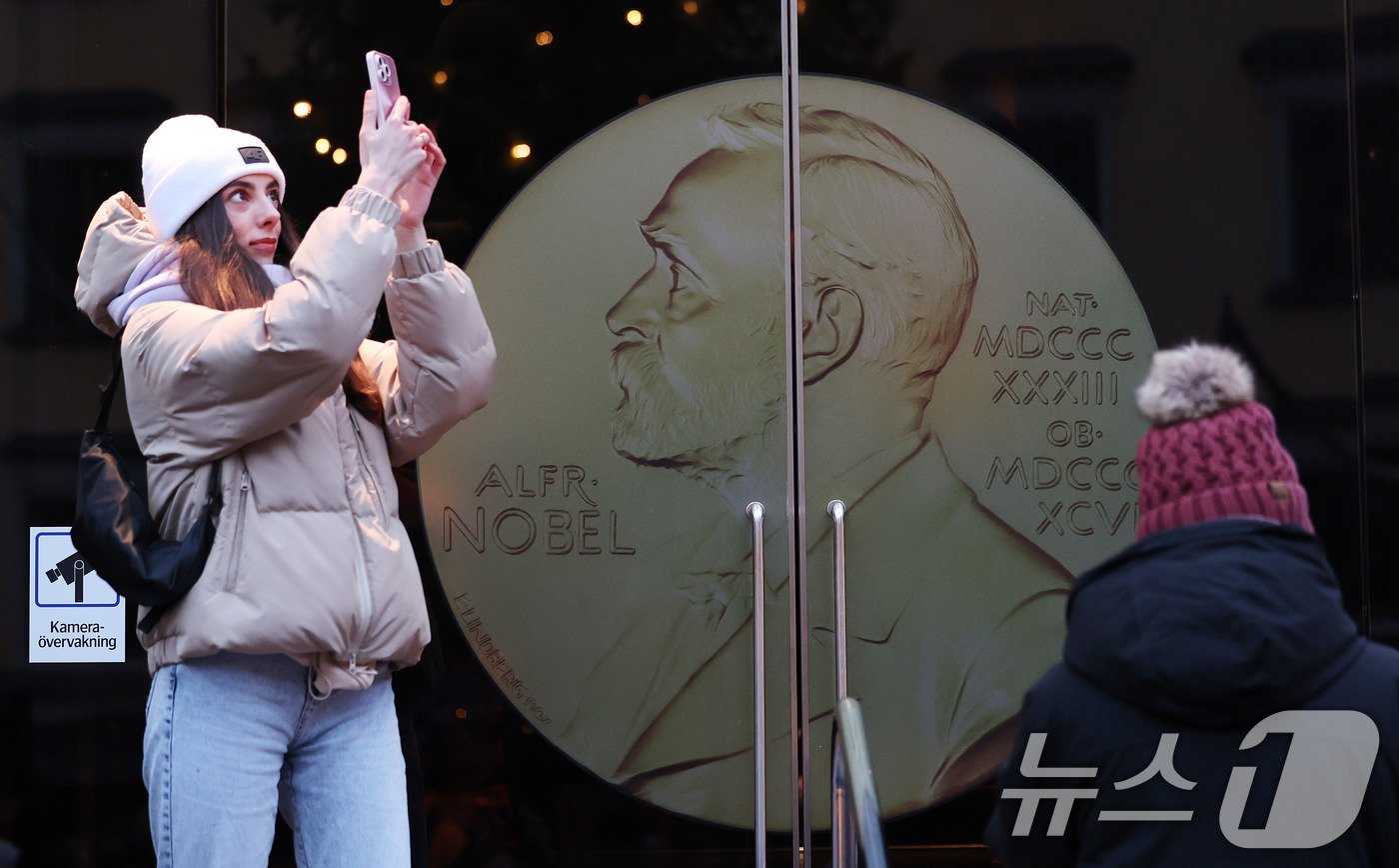 본문 이미지 - 7일&#40;현지시간&#41; 스웨덴 스톡홀름 노벨상박물관 앞에서 관광객이 기념촬영을 하고 있다. 현지는 이미 1년 중 가장 흥겨운 노벨 주간이 시작된 만큼 축제 분위기가 역력하다. 2024.12.8/뉴스1 ⓒ News1 박지혜 기자