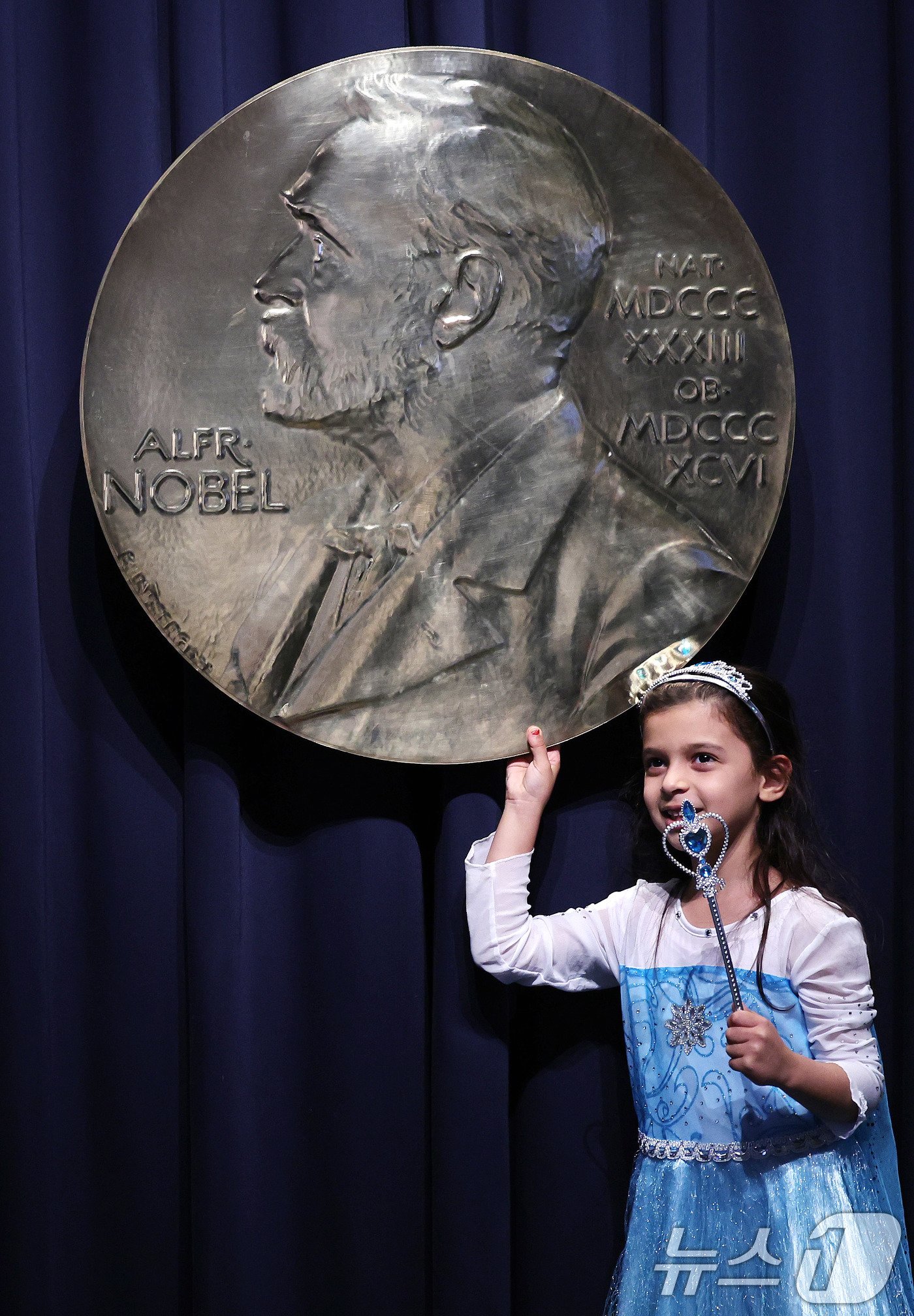 본문 이미지 - 7일&#40;현지시간&#41; 스웨덴 스톡홀름 노벨상박물관을 찾은 어린이가 노벨상 메달을 잡고 기념촬영을 하고 있다. 현지는 이미 1년 중 가장 흥겨운 노벨 주간이 시작된 만큼 축제 분위기가 역력하다. 2024.12.8/뉴스1 ⓒ News1 박지혜 기자