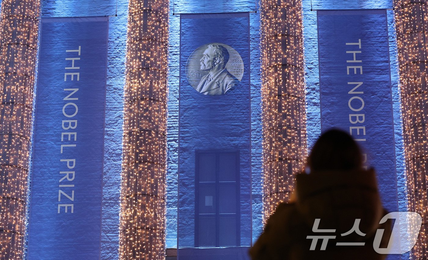 본문 이미지 - 노벨 시상식을 앞둔 7일&#40;현지시간&#41; 스웨덴 스톡홀름 콘서트홀 앞에서 한 시민이 기념촬영을 하고 있다. 오는 10일 이곳에서 노벨상 시상식이 열린다. 아시아 여성 최초 노벨문학상 수상자로 선정된 소설가 한강은 이곳에서 노벨상 메달과 증서를 받는다. 2024.12.8/뉴스1 ⓒ News1 박지혜 기자