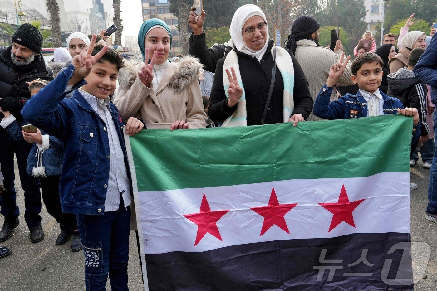 본문 이미지 - 시리아 반군이 7일&#40;현지시간&#41; 수도 다마스쿠스를 점령했다고 선언했다. 사진은 홈스에서 시리아 국민들이 승리의 상징인 V를 그리며 축하하는 모습. 2024.12.8. ⓒ AFP=뉴스1 ⓒ News1 이창규 기자
