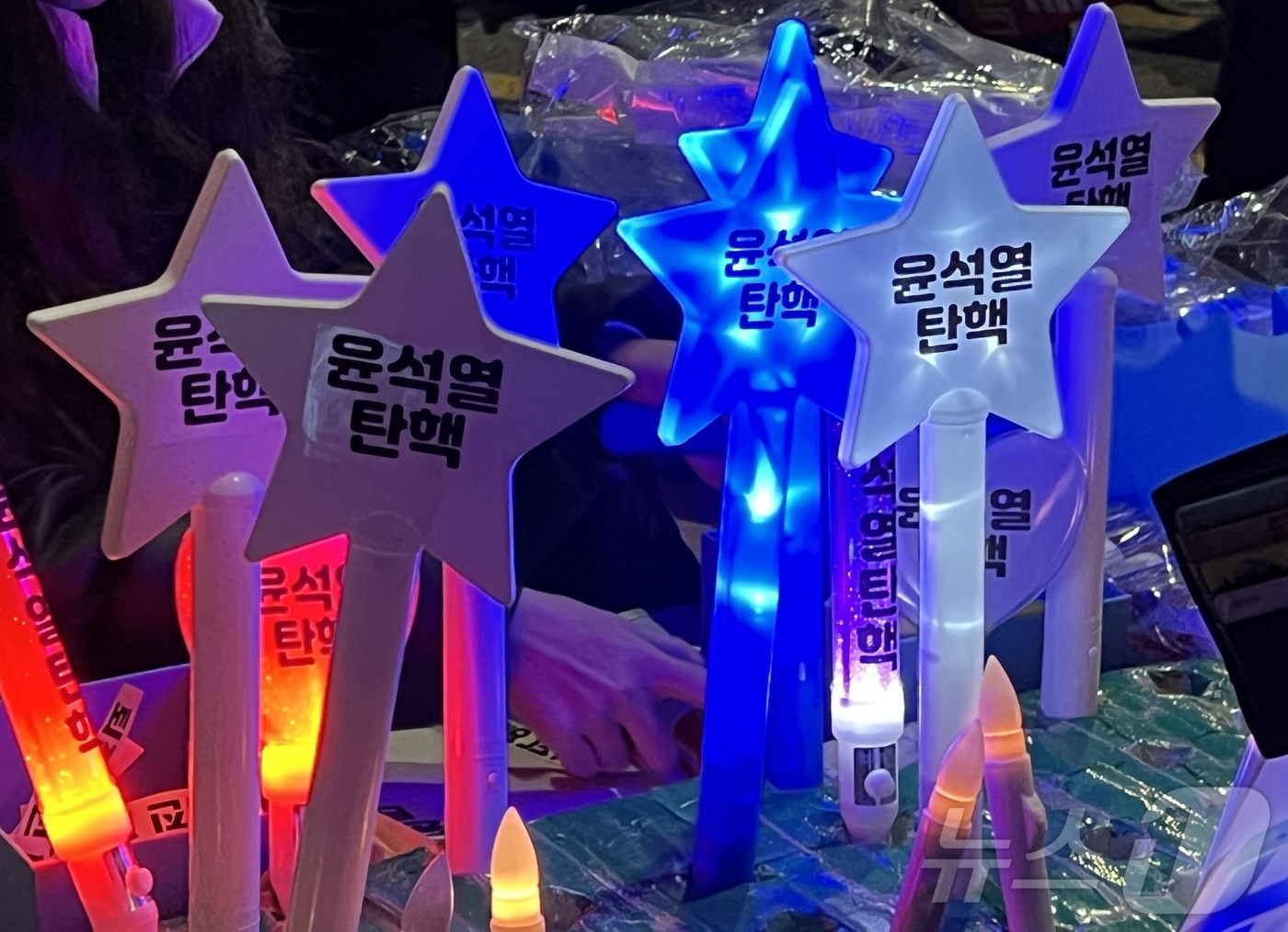 (서울=뉴스1) 김민수 기자 = 8일 오후 서울 여의도 국회의사당역 인근에서 열린 촛불문화제에서 한 상인이 시민들에게 '윤석열 탄핵'이 적힌 응원봉을 판매하고 있다. 2024.12 …