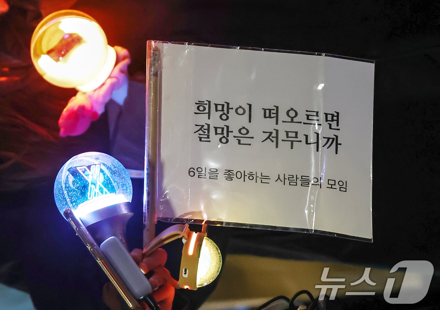 본문 이미지 - 8일 오후 서울 영등포구 여의도 국회의사당 앞에서에서 열린 촛불문화제에서 '6일을 좋아하는 사람들의 모임'이라 밝힌 참가자들이 "희망이 떠오르면 절망은 저무니까"라고 적힌 깃발과 야광봉을 들고 있다. 2024.12.08/뉴스1 ⓒ News1 민경석 기자