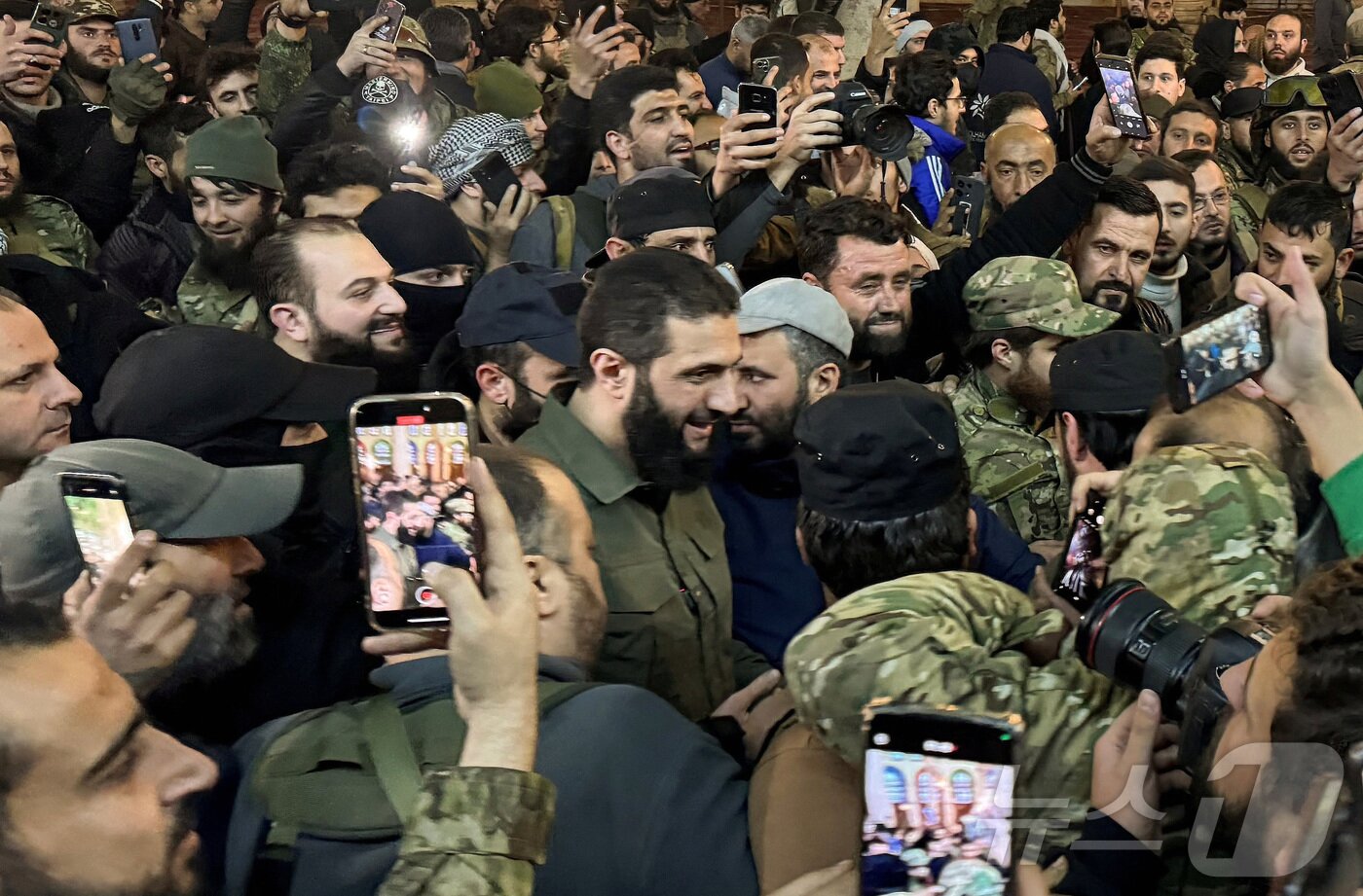 본문 이미지 - 8일&#40;현지시간&#41; 시리아 반군의 주축인 하야트타흐리트알샴&#40;HTS&#41;의 수장 아부 무함마드 알졸라니&#40;가운데&#41;가 수도 다마스쿠스를 장악한 뒤 지지자들에게 환영받고 잇다. 2024.12.08/ ⓒ 로이터=뉴스1 ⓒ News1 박재하 기자
