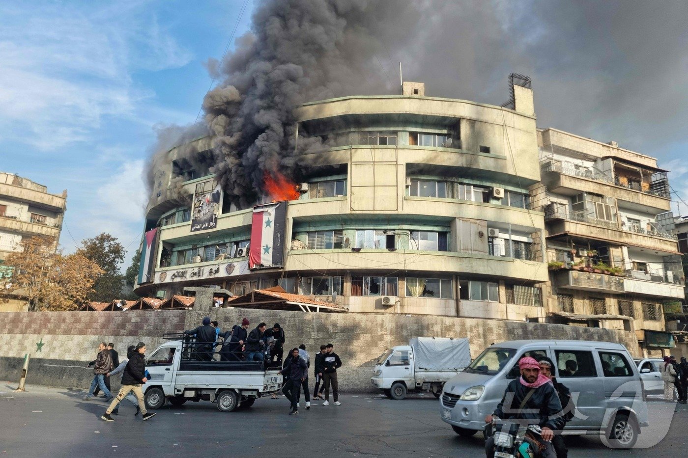 본문 이미지 - 8일&#40;현지시간&#41; 바샤르 알-아사드의 시리아 정부가 붕괴된 뒤 다마스쿠스에 있는 내무부 건물에서 화염과 검은 연기가 솟아 오르고 있다. 2024.12.09 ⓒ AFP=뉴스1 ⓒ News1 우동명 기자