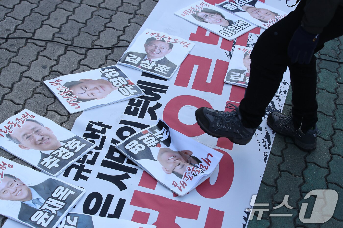 본문 이미지 - 윤석열퇴진 대구시국회의 참가자들이 9일 오전 대구 수성구 범어동 국민의힘 대구경북 당사 앞에서 '탄핵표결 거부, 내란동조 국민의힘 규탄' 기자회견을 열고, 탄핵표결을 거부한 대구경북 국민의힘 의원들의 사진을 바닥에 던진 뒤 밟고 있다. 2024.12.9/뉴스1 ⓒ News1 공정식 기자