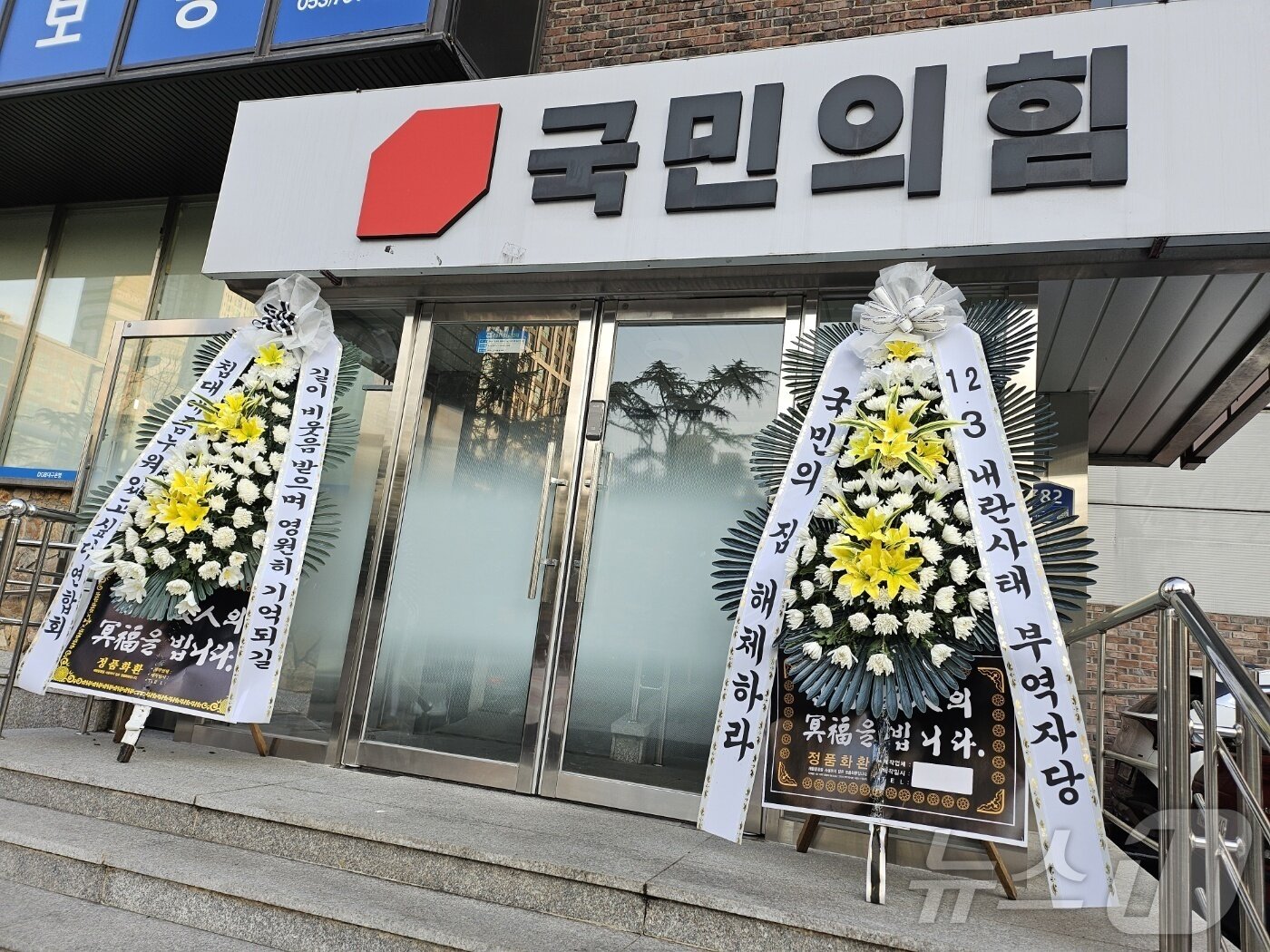 본문 이미지 - 9일 오후 대구 수성구 범어동 국민의힘 대구·경북시·도당 당사 입구에 윤석열 대통령 탄핵안 표결을 거부한 국민의힘을 규탄하는 내용의 근조(謹弔) 화환 2개가 추가로 배달돼 있다. 2024.12.9/뉴스1 ⓒ News1 남승렬 기자