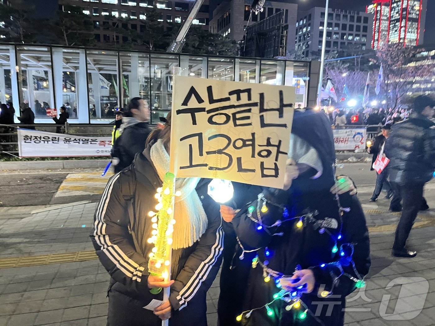 본문 이미지 - 9일 오후 7시쯤 서울 여의도 국회의사당 옆 인도에서 수능을 마친 고등학교 학생들이 깃발을 들고 있다. 2024.12.9/뉴스1