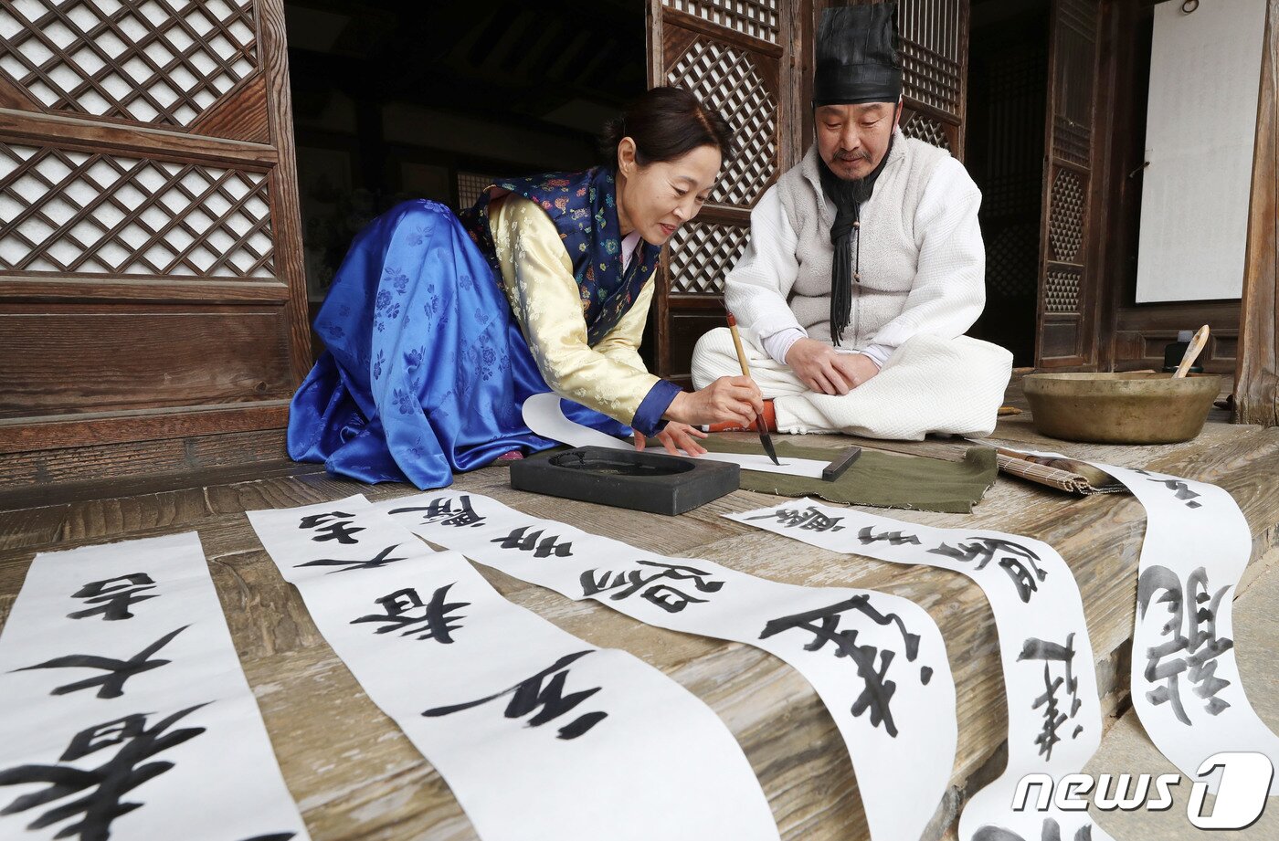 본문 이미지 - 절기상 입춘(立春)을 사흘 앞둔 1일 경기 용인시 기흥구 한국민속촌에서 직원들이 새해의 복을 기원하는 마음을 담아 입춘첩을 쓰고 있다 입춘첩에는 보통 ‘입춘대길(立春大吉) 건양다경(建陽多慶)’(봄이 시작되니 크게 길하고, 경사스러운 일이 많이 생긴다.), ‘소지황금출(掃地黃金出) 개문만복래(開門萬福來)’(땅을 쓸면 황금이 생기고 문을 열면 만복이 온다) 등의 글씨를 써 붙였다. 봄을 기다리는 마음과 한 해 동안의 길한 운과 경사스러움이 가득하기를 기원하는 의미가 담겨있다. 2024.2.1/뉴스1 ⓒ News1 김영운 기자