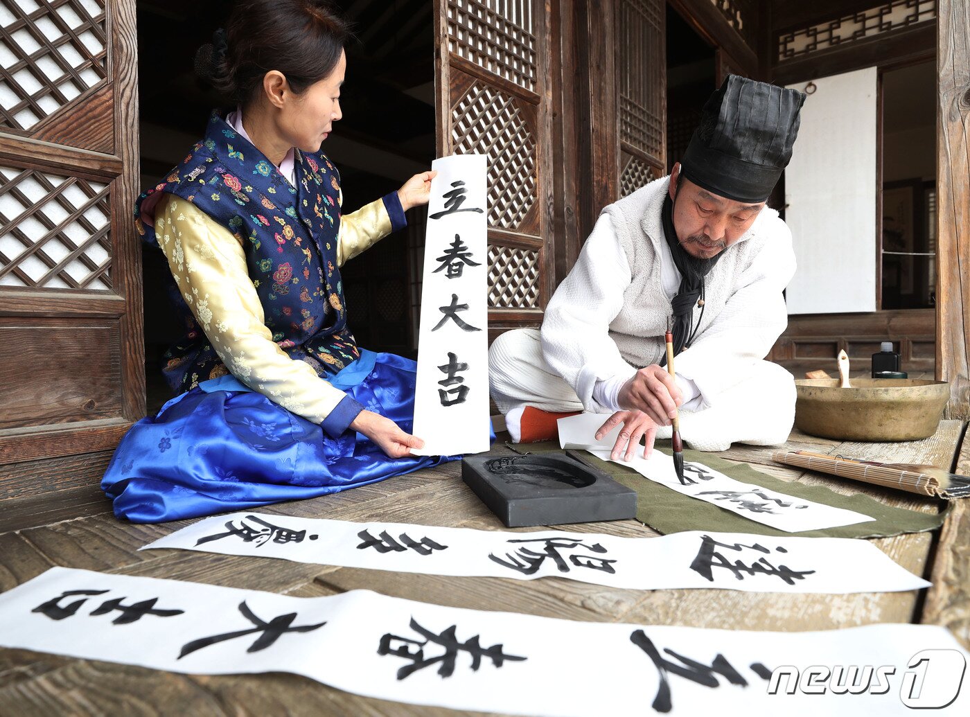 본문 이미지 - 절기상 입춘(立春)을 사흘 앞둔 1일 경기 용인시 기흥구 한국민속촌에서 직원들이 새해의 복을 기원하는 마음을 담아 입춘첩을 쓰고 있다 입춘첩에는 보통 ‘입춘대길(立春大吉) 건양다경(建陽多慶)’(봄이 시작되니 크게 길하고, 경사스러운 일이 많이 생긴다.), ‘소지황금출(掃地黃金出) 개문만복래(開門萬福來)’(땅을 쓸면 황금이 생기고 문을 열면 만복이 온다) 등의 글씨를 써 붙였다. 봄을 기다리는 마음과 한 해 동안의 길한 운과 경사스러움이 가득하기를 기원하는 의미가 담겨있다. 2024.2.1/뉴스1 ⓒ News1 김영운 기자